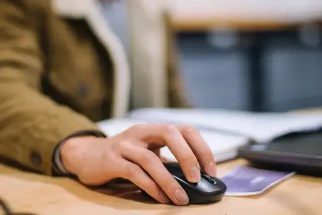 Student using a laptop with a mouse